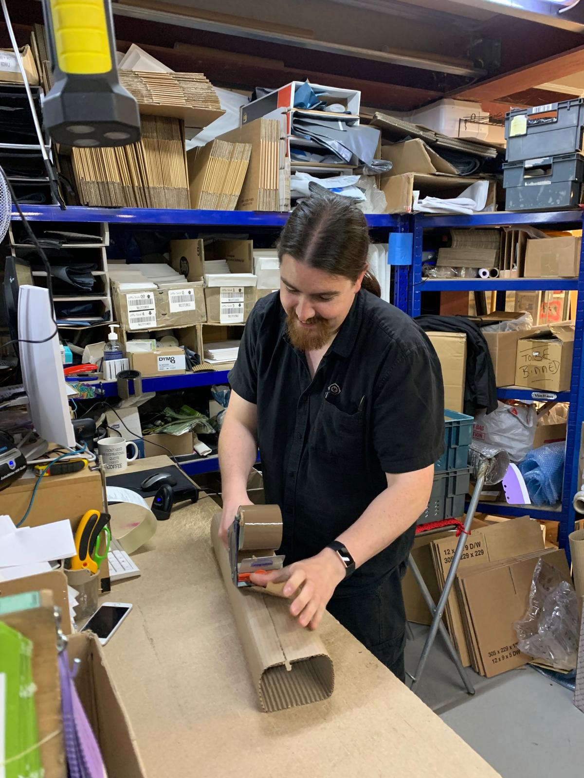 OFEX team member hand-finishing a parcel at the packing bench